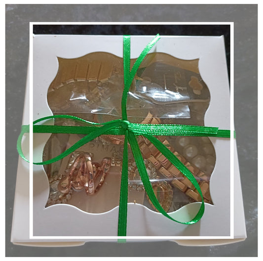 Chocolate bar in a decorative box with a green ribbon on a gray background